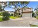 Daytime view of a two-story home with red tile roof, manicured lawn, and a large shade tree at 3307 W Knights Ave, Tampa, FL 33611