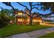Inviting two-story home with lush green lawn, mature tree, and meticulously maintained landscaping at 3307 W Knights Ave, Tampa, FL 33611