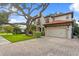Beautiful two-story home with a red tile roof and a lush green front yard with a large shade tree at 3307 W Knights Ave, Tampa, FL 33611