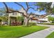 Charming two-story home with manicured lawn, mature tree, and beautiful landscaping at 3307 W Knights Ave, Tampa, FL 33611
