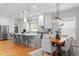 Open-concept living space featuring a kitchen island, dining area, and contemporary lighting fixtures at 3307 W Knights Ave, Tampa, FL 33611