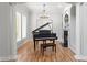 Elegant music room featuring a Yamaha grand piano, a fireplace, and stylish light fixture at 3307 W Knights Ave, Tampa, FL 33611