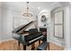 Elegant music room featuring a Yamaha grand piano, a fireplace, and stylish light fixture at 3307 W Knights Ave, Tampa, FL 33611