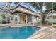 Exterior view of a screened-in pool with covered patio seating area at 3307 W Knights Ave, Tampa, FL 33611