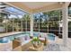 Covered patio with wicker seating overlooks a beautiful screened-in pool at 3307 W Knights Ave, Tampa, FL 33611