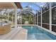 View of a screened-in pool and covered patio area with comfortable seating at 3307 W Knights Ave, Tampa, FL 33611