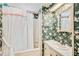Bathroom featuring floral wallpaper, shower/tub combo and sink with vanity and an ornate framed mirror at 37812 Valencia Ave, Zephyrhills, FL 33541