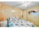 Bedroom with wood-look wall paneling, ceiling fan, and a bed with a floral pattern comforter at 37812 Valencia Ave, Zephyrhills, FL 33541