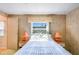 Serene bedroom offers natural light, vintage lamps and wood walls at 37812 Valencia Ave, Zephyrhills, FL 33541