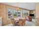 A dining table seats four in this brightly lit dining room with large windows and view to a living room at 37812 Valencia Ave, Zephyrhills, FL 33541