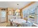 Cozy dining area with a round table, cushioned chairs, and a large window overlooking the neighborhood at 37812 Valencia Ave, Zephyrhills, FL 33541