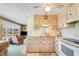 Bright kitchen featuring wood cabinets, a neutral countertop, and appliances, with an adjacent sitting area at 37812 Valencia Ave, Zephyrhills, FL 33541
