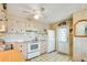 Functional kitchen with white appliances and wood-look cabinets at 37812 Valencia Ave, Zephyrhills, FL 33541