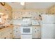 Practical kitchen with white appliances and wood-look cabinetry at 37812 Valencia Ave, Zephyrhills, FL 33541