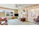 Well lit living room includes TV, rocking chair, side tables, lamps, ceiling fan and view of a neighborhood street at 37812 Valencia Ave, Zephyrhills, FL 33541