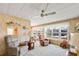 A well lit living room offers ample seating, carpeting, ceiling fan and several windows with a neighborhood view at 37812 Valencia Ave, Zephyrhills, FL 33541