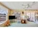 Relaxing living room featuring a TV, comfortable seating, ceiling fan and access to an enclosed porch at 37812 Valencia Ave, Zephyrhills, FL 33541