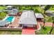 This home features a detached garage, a backyard pool with brick pavers, lush green landscaping, and a relaxing outdoor fire pit at 4002 Hudson Ter, Tampa, FL 33618
