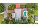Aerial view of home showcasing backyard pool, detached garage, brick driveway, with vibrant landscaping and mature trees at 4002 Hudson Ter, Tampa, FL 33618