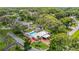 An aerial view showing the property with a private pool, white fence, mature trees, and a long red driveway at 4002 Hudson Ter, Tampa, FL 33618