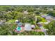 An aerial view of a home featuring a backyard pool, detached garage, mature trees and lush greenery at 4002 Hudson Ter, Tampa, FL 33618
