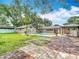 Inviting backyard featuring a sparkling pool, lush landscaping, brick patio, and covered seating area, perfect for outdoor entertaining at 4002 Hudson Ter, Tampa, FL 33618