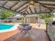 Covered patio adjacent to backyard pool, creating an ideal outdoor entertaining space at 4002 Hudson Ter, Tampa, FL 33618