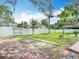 Large backyard featuring a brick patio, a white fence, well maintained grass, and mature trees, providing ample space for recreation at 4002 Hudson Ter, Tampa, FL 33618