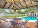 Backyard with a covered patio, an outdoor dining set, and a swimming pool at 4002 Hudson Ter, Tampa, FL 33618