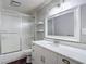 Bathroom with white cabinets, white countertop, large mirror, and shower with sliding glass door at 4002 Hudson Ter, Tampa, FL 33618
