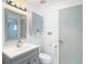 Bathroom featuring gray vanity, mirror, white toilet and cabinet, creating a functional space at 4002 Hudson Ter, Tampa, FL 33618