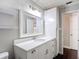 Bathroom featuring white cabinets, a large mirror, and modern vanity lighting at 4002 Hudson Ter, Tampa, FL 33618