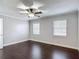 A cozy bedroom features hardwood floors, two windows, and a ceiling fan at 4002 Hudson Ter, Tampa, FL 33618
