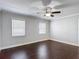 Bedroom featuring hardwood floors, a ceiling fan, and two windows with horizontal blinds at 4002 Hudson Ter, Tampa, FL 33618