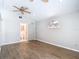 Bedroom with wood-look tile, ceiling fan, half moon window, and ensuite bathroom entrance at 4002 Hudson Ter, Tampa, FL 33618
