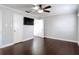 A spacious bedroom featuring hardwood floors, a ceiling fan, a TV, and a walk-in closet at 4002 Hudson Ter, Tampa, FL 33618