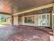 Home featuring brick flooring in the covered entryway, stylish front door, and manicured landscape at 4002 Hudson Ter, Tampa, FL 33618