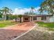 Attractive single-story home with brick driveway, a covered front porch, and lush green lawn at 4002 Hudson Ter, Tampa, FL 33618