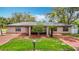 Inviting single-story home boasts a brick driveway, a well-kept lawn, and beautiful landscaping at 4002 Hudson Ter, Tampa, FL 33618