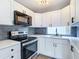 Updated kitchen showcasing white cabinets, gray backsplash and stainless steel appliances at 4002 Hudson Ter, Tampa, FL 33618