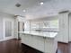 Bright kitchen with stainless steel appliances, white cabinets and countertops, and a large kitchen island at 4002 Hudson Ter, Tampa, FL 33618