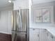 Stainless steel refrigerator with white cabinets and countertops in a bright kitchen with a large window at 4002 Hudson Ter, Tampa, FL 33618