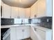 Bright kitchen featuring white cabinets, gray backsplash, and ample counter space at 4002 Hudson Ter, Tampa, FL 33618