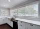 Bright kitchen with stainless steel appliances, white cabinets and countertops, and a large window view at 4002 Hudson Ter, Tampa, FL 33618