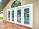 Pool house with a wall of white-framed glass doors offering views of the pool at 4002 Hudson Ter, Tampa, FL 33618