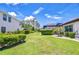 Large back yard featuring a well-maintained lawn, mature hedges, and a screened-in lanai at 4122 Natural Vista Ct, New Port Richey, FL 34655