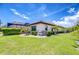 Green back yard features mature landscaping and hardscape surrounding the AC system with a screened lanai at 4122 Natural Vista Ct, New Port Richey, FL 34655
