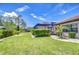 Expansive backyard boasts a lush lawn, privacy hedges, and a screened-in outdoor living space at 4122 Natural Vista Ct, New Port Richey, FL 34655