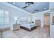 Bright bedroom featuring two ceiling fans, shuttered windows, and modern wood-look flooring at 4122 Natural Vista Ct, New Port Richey, FL 34655
