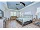 Spacious bedroom featuring tray ceiling, wood floors, plantation shutters, and stylish furniture at 4122 Natural Vista Ct, New Port Richey, FL 34655